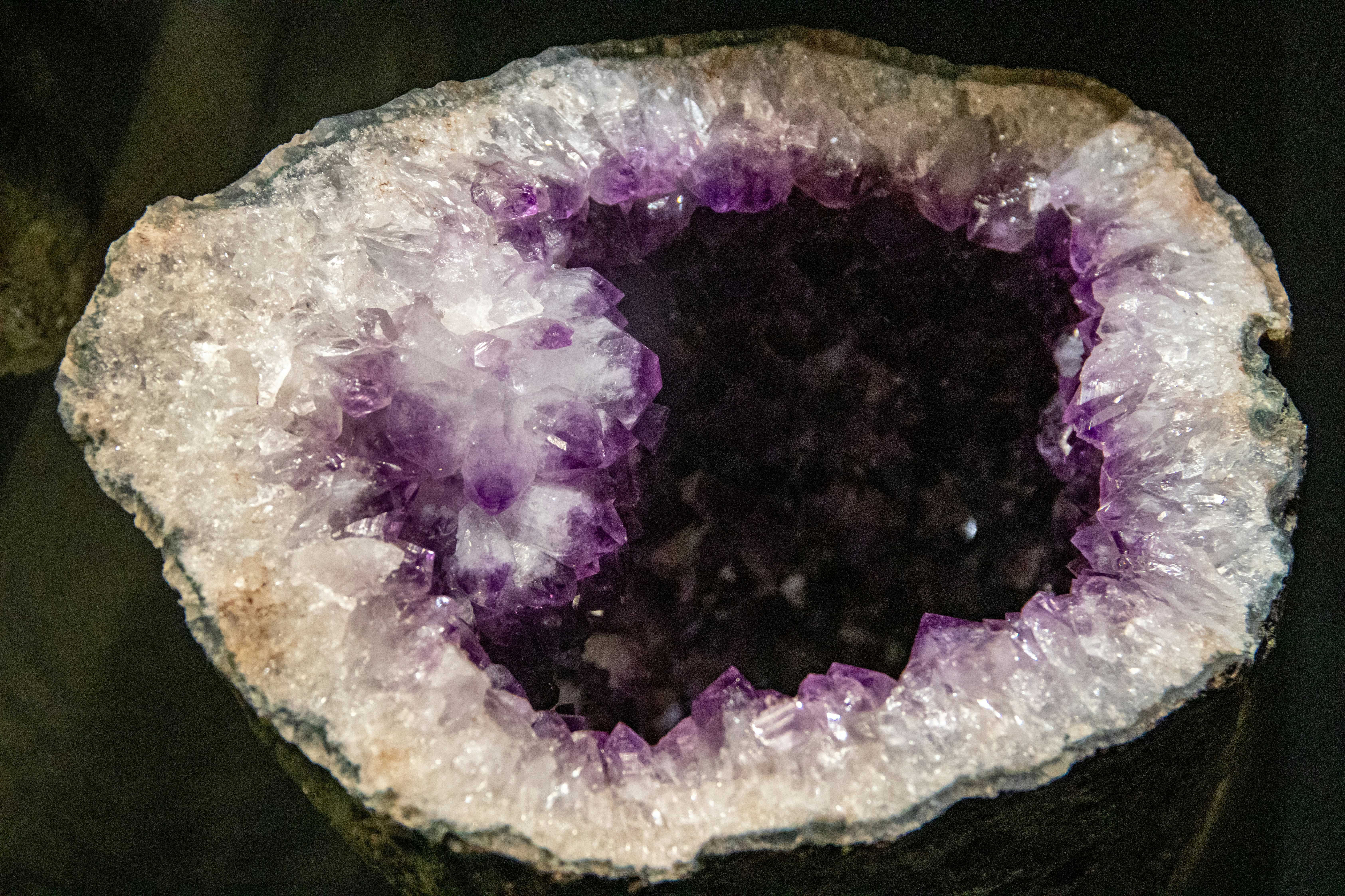Open amethyst geode with a ring of purple crystal points around a dark hollow center